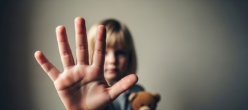 Kind zeigt Stopp-Geste mit der Hand zum Schutz vor Gewalt und Missbrauch. Kinderschutz, Prävention und soziale Hilfe Konzept.